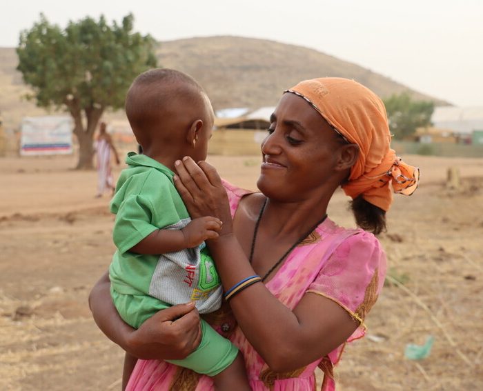 Akbert playing with her youngest 1 year old son, Um-Rakoba Refugees' Camp, Gedarif State, Sudan, February 2021.

This case study follows a 35 years old single mother of 7, Akbert Gebremariaw, from Abderafi, Ethiopia. She lost her husband in the conflict and now settles in Um-Rakuba Refugee Camp, Gedarif State, Sudan. The study describes what happened back home and her day to day activities. 

The Um-Rakuba Refugee Camp in Gedarif Sate of Sudan is currently home to over 20,000 refugees who have fled conflict in Ethiopia. Islamic Relief has responded to the refugee crisis since November 2020 and has provided food items among other essential items. Islamic Relief has also provided non-food items such as kitchen utensils and also hygeine kits for women and girls. We have also built latrines and washing facilities at the camp. Islamic Relief continues to work at Um-Rakuba Refugee Camp providing the most essential assistance to the refugees. 