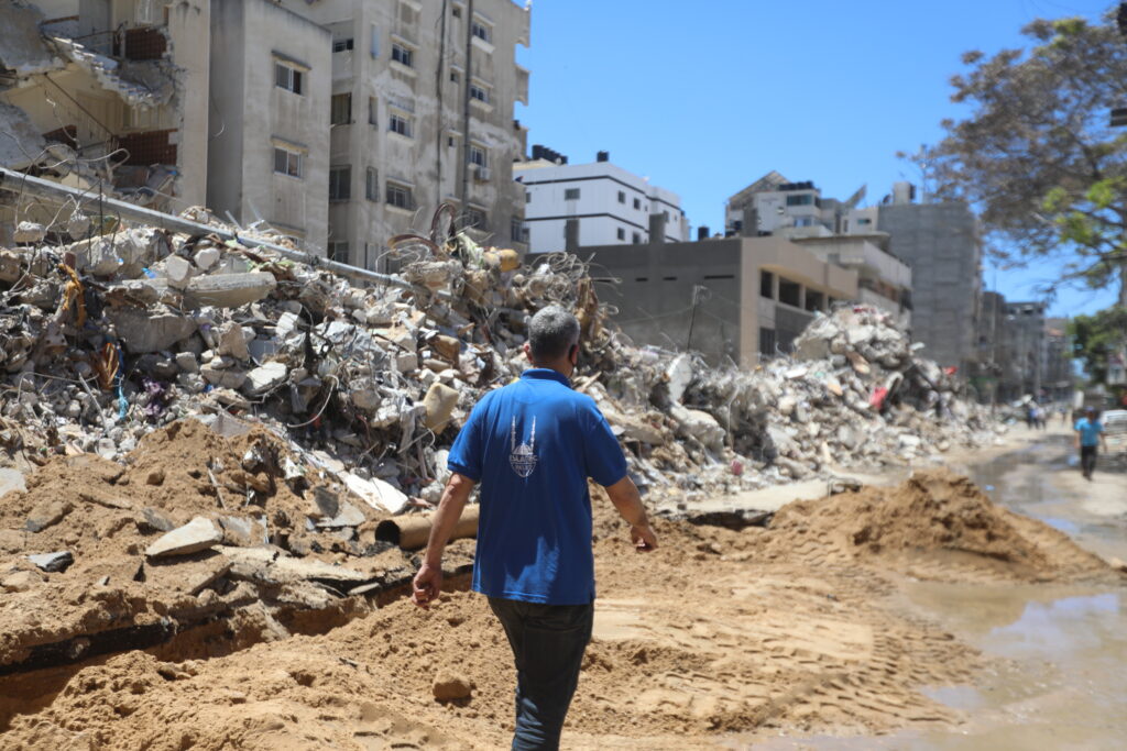 Membro dello staff di Islamic Relief cammina tra le macerie di Gaza